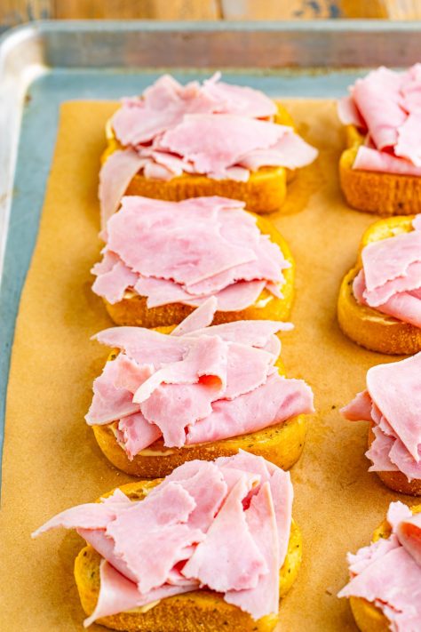 Sauce and ham on pieces of Texas Toast.
