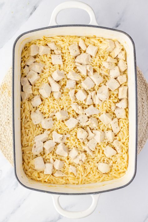 A partially baked Lemon Chicken and Orzo in a baking dish.