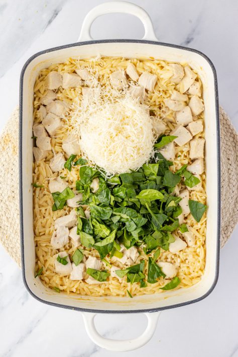 Parmesan and spinach in a baking dish with the rest of the Lemon Chicken and Orzo.