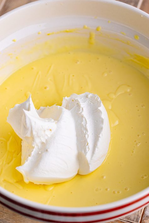 Whipped topping being added to a creamy mixture.