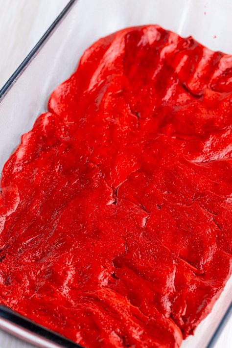 Cake batter being pressed into a baking dish.