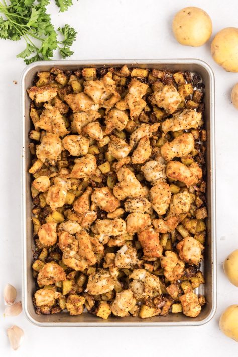 Seasoned and cooked potatoes and chicken on a sheet pan.