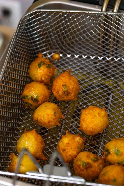 Shrimp Fritters being fried in a basket.
