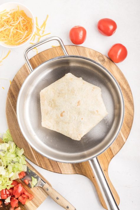 A Crunchwrap being cooked in a skillet.