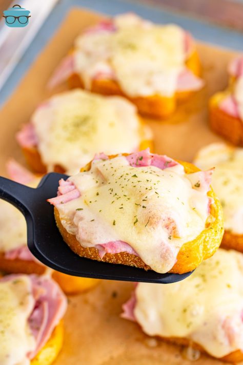 A utensil lifting a piece of Ham and Swiss Texas Toast.